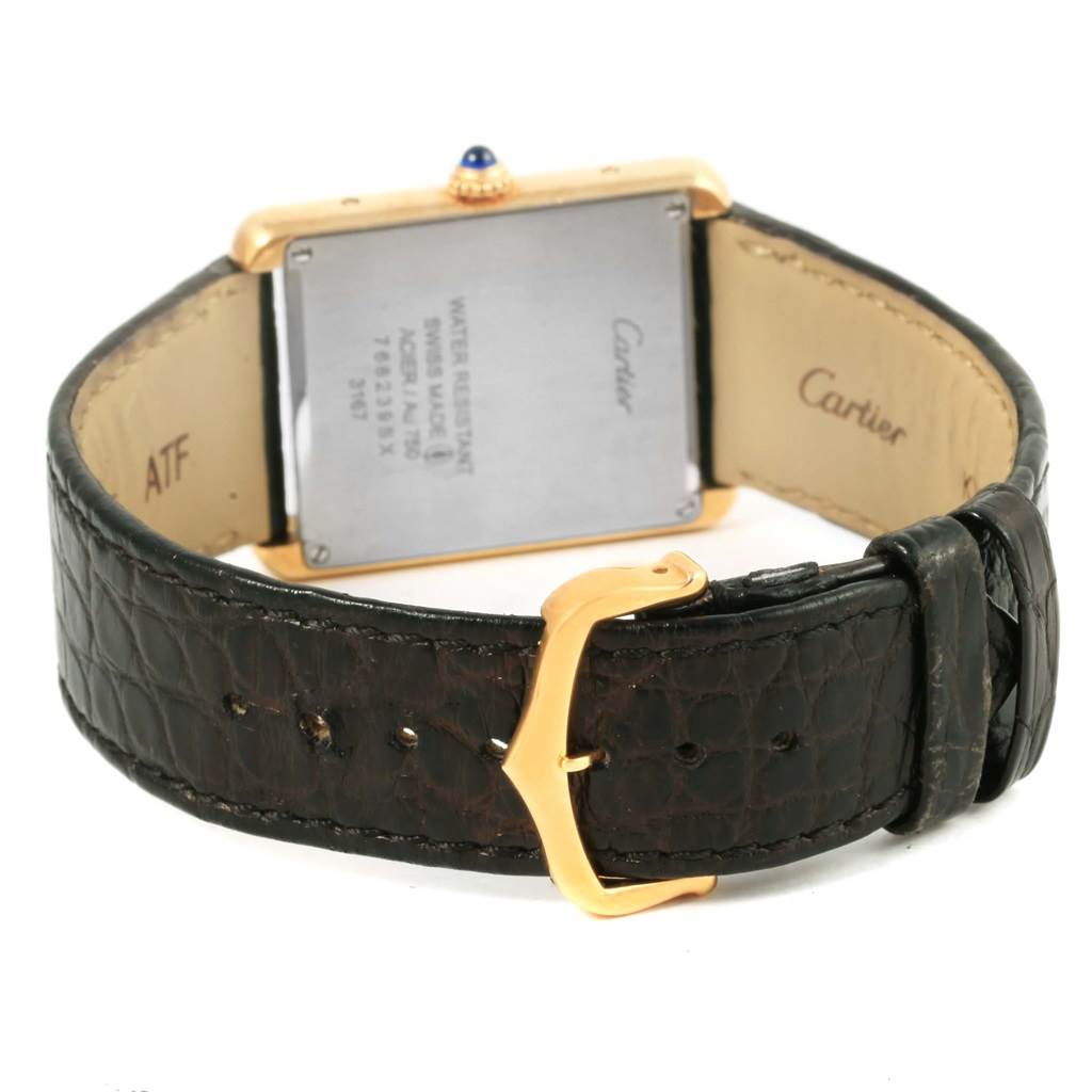 The image shows the Tank Solo model by Cartier from a rear angle, highlighting the case back and leather strap with buckle.