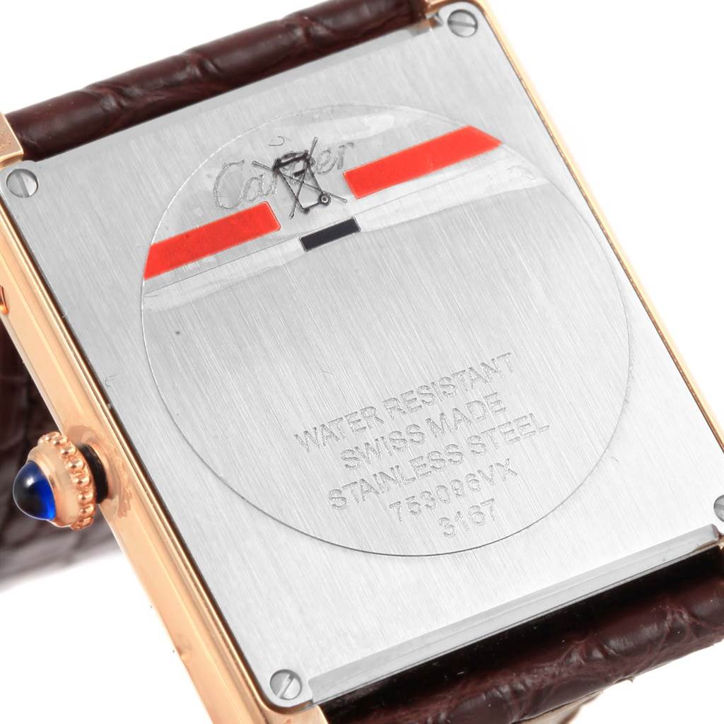 The image shows the back of a Cartier Tank Solo W5200025 Steel and Gold (two tone) Silver Dial W5200025 Steel and Gold (two tone) Silver Dial watch, highlighting the stainless steel case and the crown with a blue cabochon.