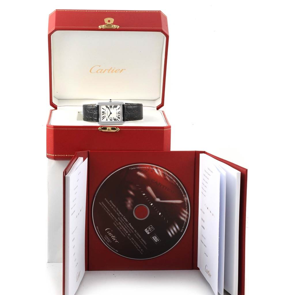 The image shows a Cartier Tank Solo W1018355 Stainless Steel Silver Dial W1018355 Stainless Steel Silver Dial watch inside its red box, alongside an open booklet and a CD.