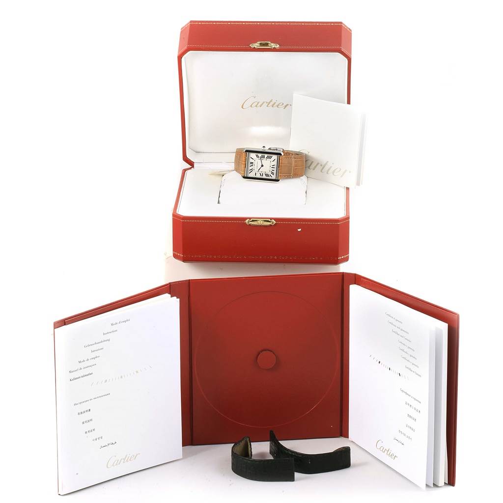 The image shows a Cartier Tank Solo W1018355 Stainless Steel Silver Dial W1018355 Stainless Steel Silver Dial watch with its original box, extra strap, and accompanying booklets.