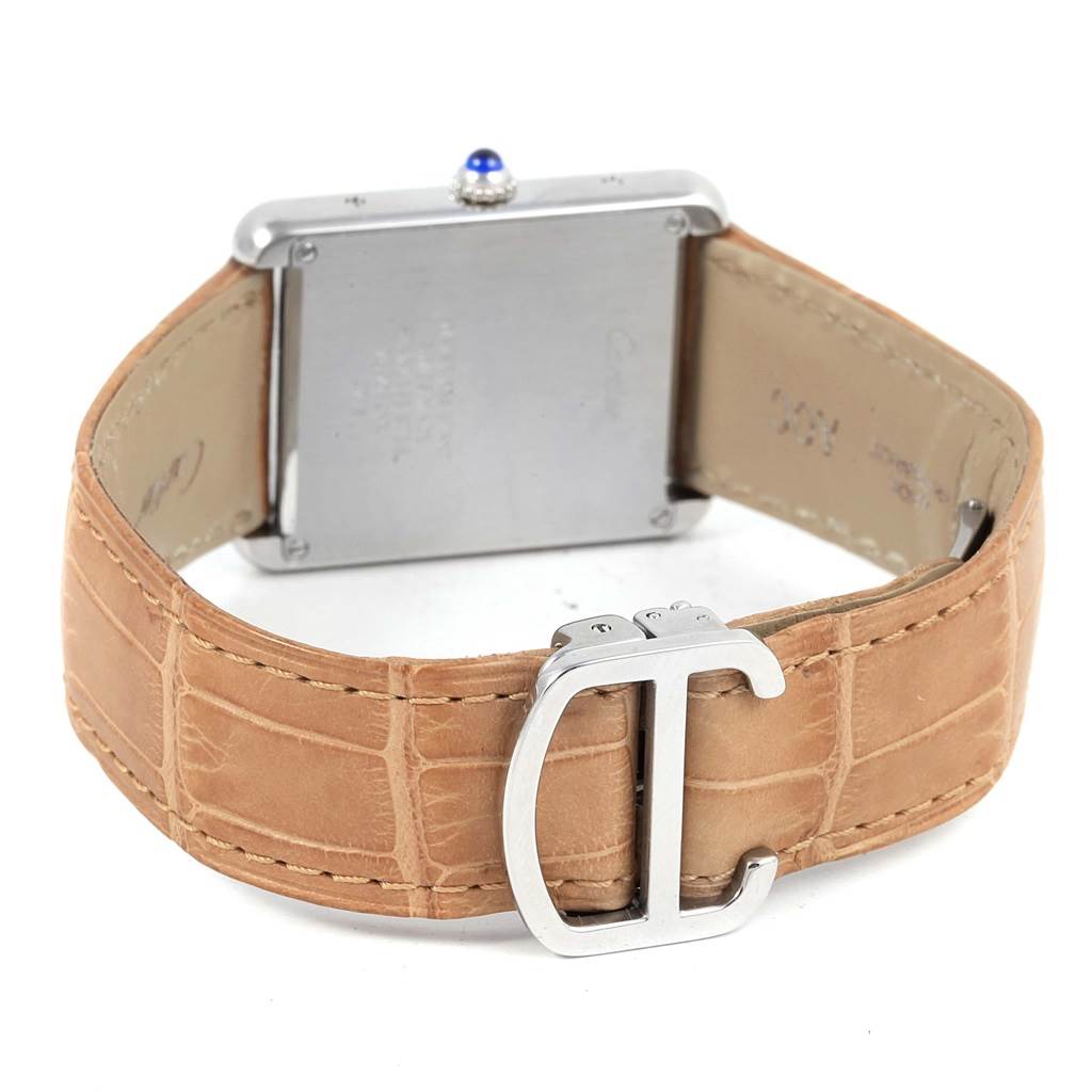 The image shows the back view of a Cartier Tank Solo W1018355 Stainless Steel Silver Dial W1018355 Stainless Steel Silver Dial watch, highlighting its case back, crown, and beige leather strap with a buckle.