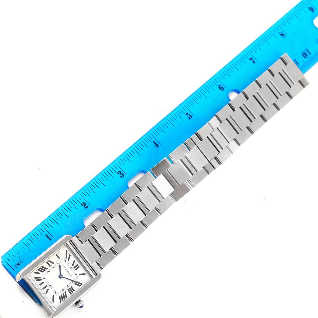 The image shows the Cartier Tank Solo W5200014 Stainless Steel Silver Dial W5200014 Stainless Steel Silver Dial watch laid flat next to a ruler, displaying its face and metal bracelet.