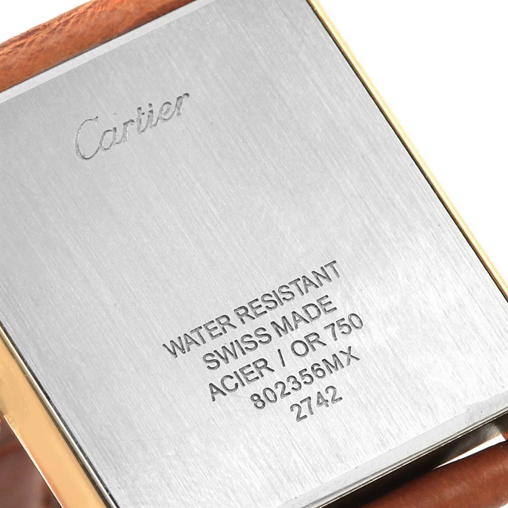 The image shows the back case of a Cartier Tank Solo W1018855 Steel and Gold (two tone) Silver Dial W1018855 Steel and Gold (two tone) Silver Dial watch, featuring engravings and part of the leather strap.