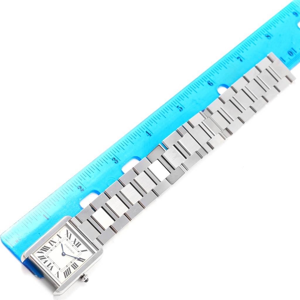 The Cartier Tank Solo W5200014 Men
s Stainless Steel Silver Dial W5200014 Men
s Stainless Steel Silver Dial watch is shown lying flat with its face and metal bracelet visible, alongside a blue ruler for scale.