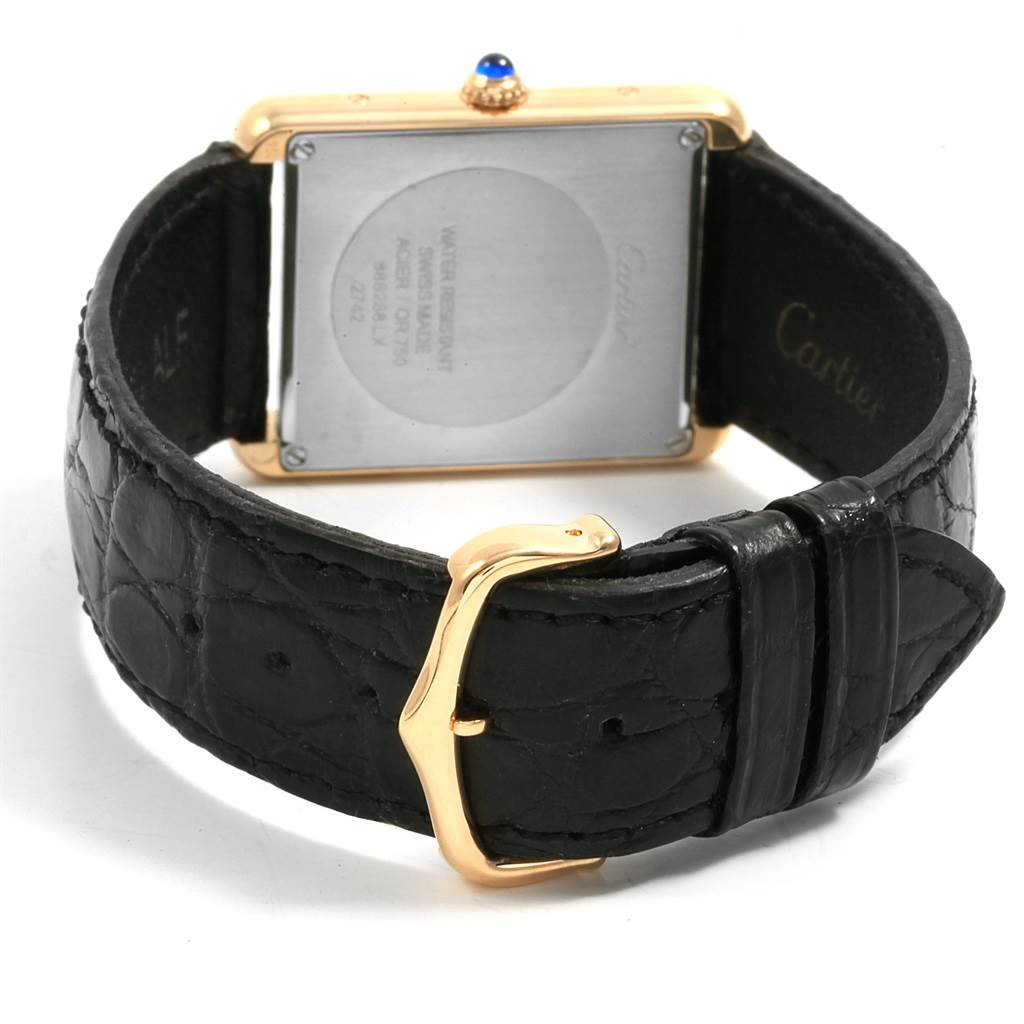 The image shows the back view of a Cartier Tank Solo W1018855 Steel and Gold (two tone) Silver Dial W1018855 Steel and Gold (two tone) Silver Dial watch, featuring its square case, cabochon crown, and black leather strap with a gold buckle.