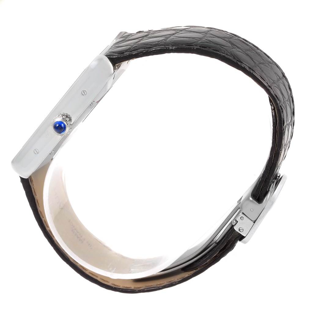 This image shows a side view of the Cartier Tank Solo W5200027 Men
s Stainless Steel Silver Dial W5200027 Men
s Stainless Steel Silver Dial watch, highlighting its crown with a blue cabochon and part of the leather strap.