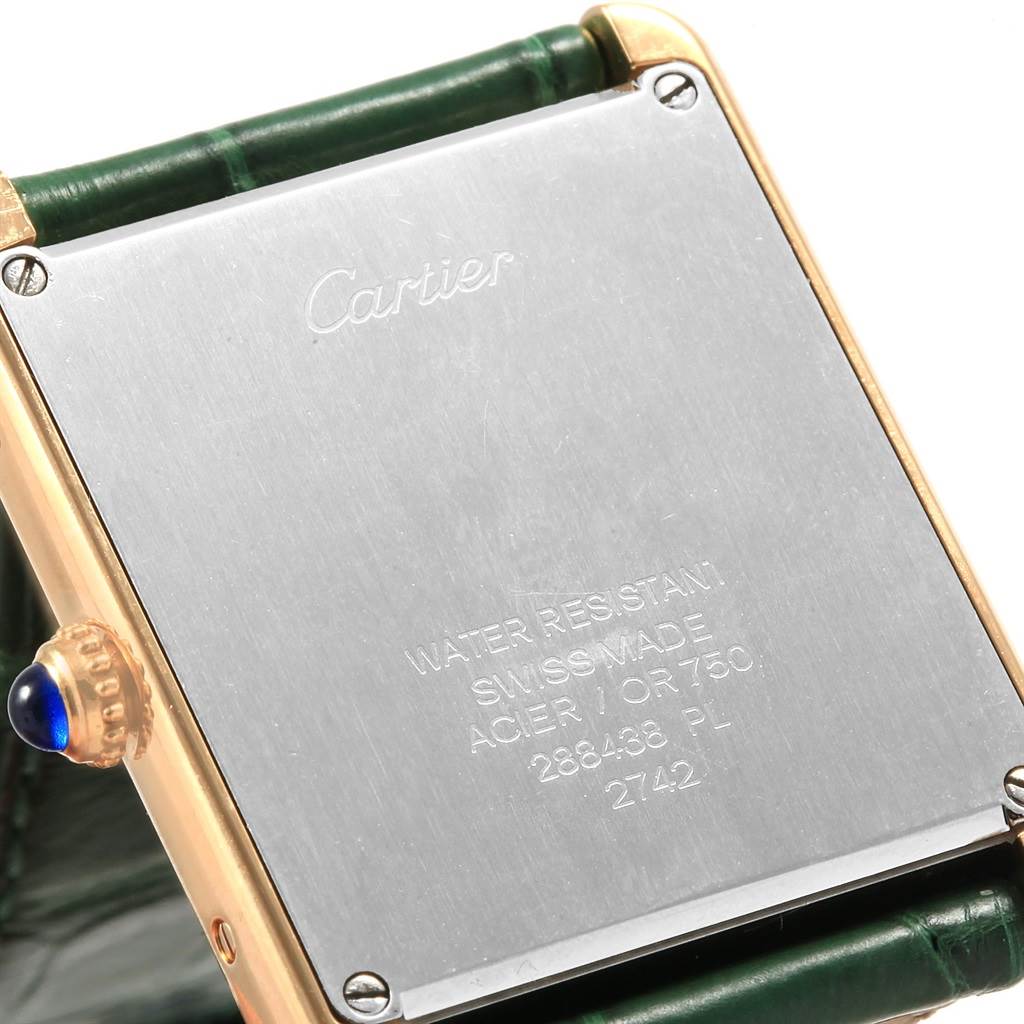 The image shows the back of the Tank Solo model by Cartier, focusing on the case back and part of the crown with a blue cabochon.