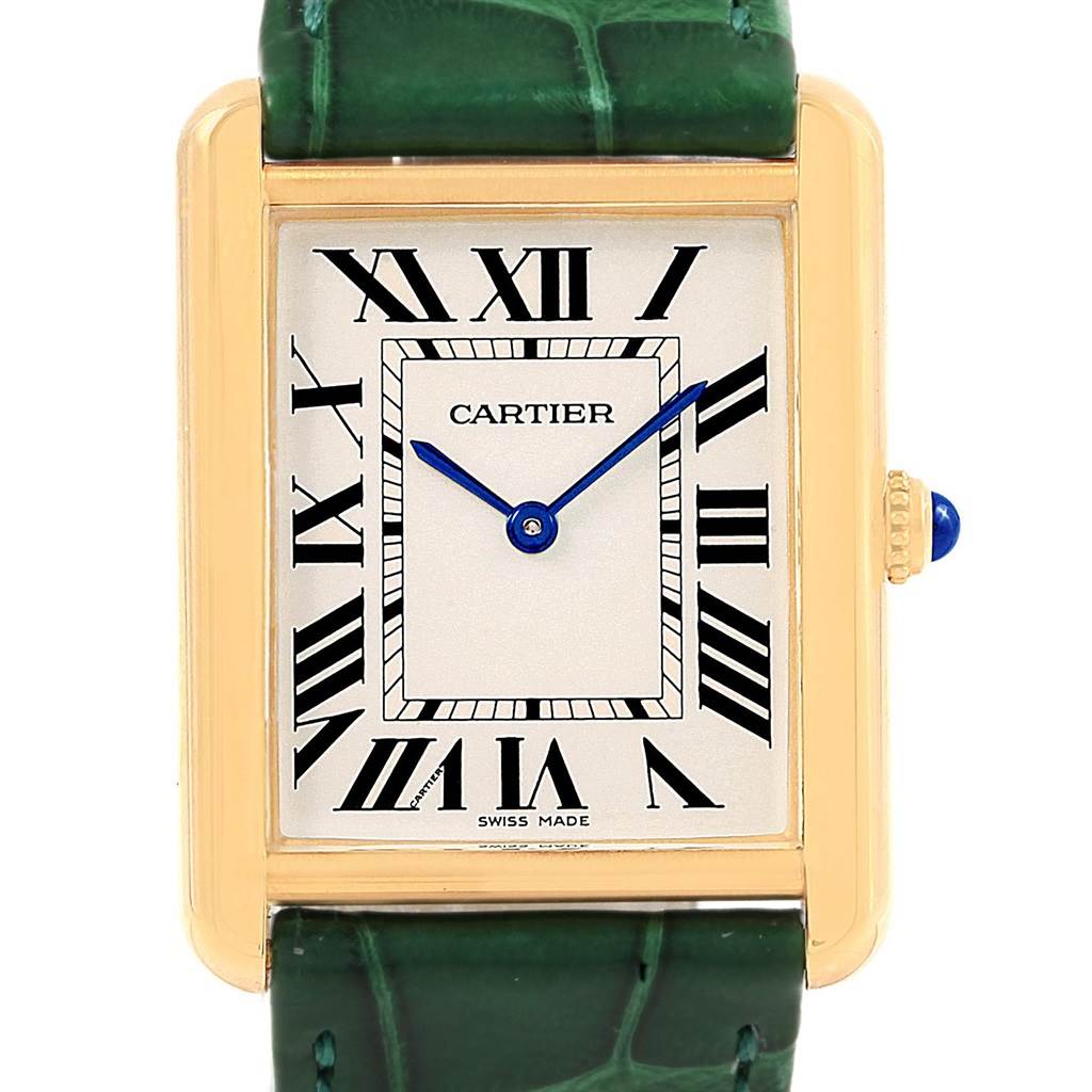 The image shows a front view of a Cartier Tank Solo W1018855 Steel and Gold (two tone) Silver Dial W1018855 Steel and Gold (two tone) Silver Dial watch, highlighting its face, Roman numerals, blue hands, and part of the green strap.