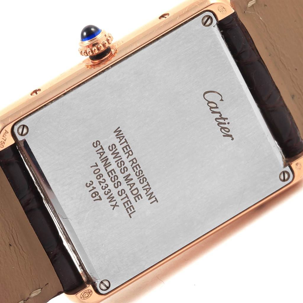 The image shows the back of a Cartier Tank Solo W5200025 Women's Steel and Gold (two tone) Silver Dial W5200025 Women's Steel and Gold (two tone) Silver Dial watch, highlighting its stainless steel case back and crown with a blue cabochon.