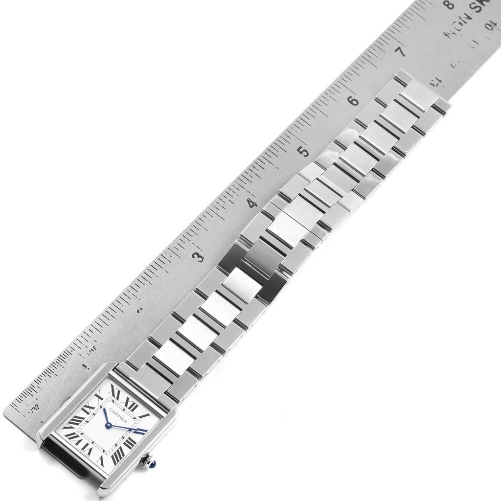 The image shows a Cartier Tank Solo W5200014 Men
s Stainless Steel Silver Dial W5200014 Men
s Stainless Steel Silver Dial watch from a top view, displaying the face and full metal strap next to a ruler for size comparison.