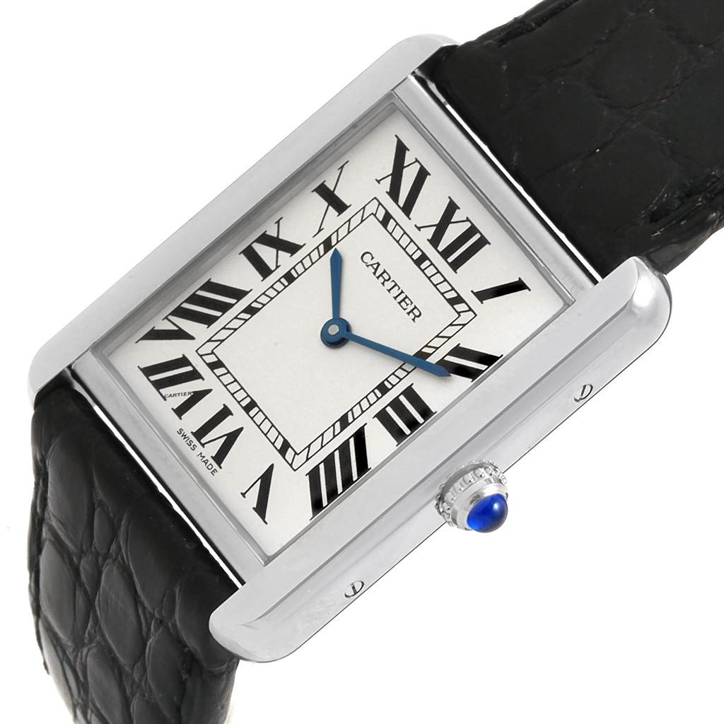 The Cartier Tank Solo W1018355 Men
s Stainless Steel Silver Dial W1018355 Men
s Stainless Steel Silver Dial watch is shown at an angle highlighting its rectangular dial, Roman numerals, blue hands, and black leather strap.