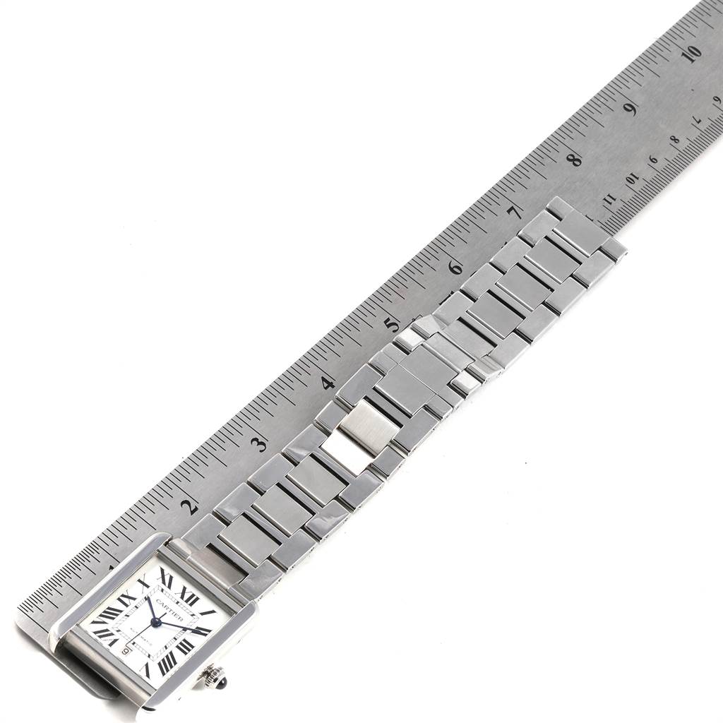 The image shows a Cartier Tank Solo W5200028 Men
s Stainless Steel Silver Dial W5200028 Men
s Stainless Steel Silver Dial watch laid flat next to a ruler, displaying the watch face and metal bracelet.