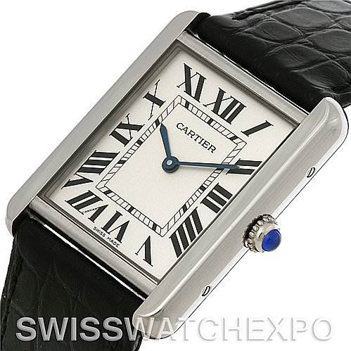 The image shows a Cartier Tank Solo W1018355 Men's Stainless Steel Silver Dial W1018355 Men's Stainless Steel Silver Dial watch from an angle highlighting its face, Roman numeral hour markers, and crown with a blue cabochon.