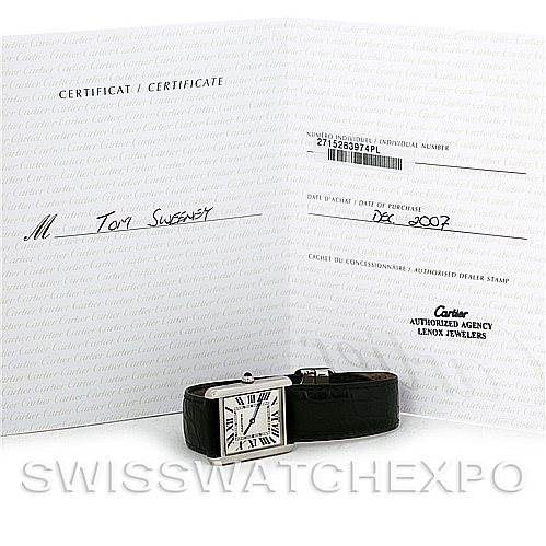The image shows a Cartier Tank Solo W1018355 Men's Stainless Steel Silver Dial W1018355 Men's Stainless Steel Silver Dial watch laid flat with its certificate propped up behind it.