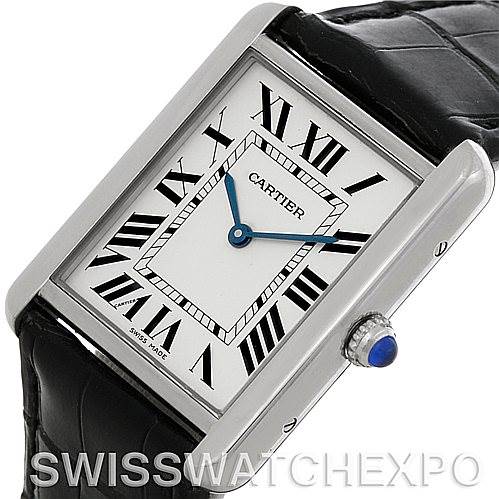 This image shows a Cartier Tank Solo W1018355 Men
s Stainless Steel Silver Dial W1018355 Men
s Stainless Steel Silver Dial watch at a tilted angle, highlighting the rectangular face, Roman numerals, and crown with a blue cabochon.