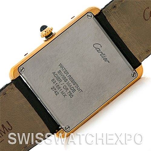 The image displays the back case and part of the strap of a Cartier watch, including inscriptions and a side view of the crown.