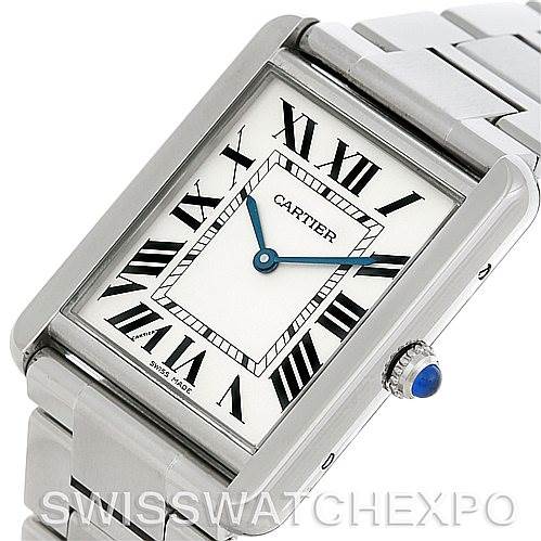 The image shows a Cartier Tank Solo W5200014 Men
s Stainless Steel Silver Dial W5200014 Men
s Stainless Steel Silver Dial watch at a slight angle displaying the face, crown with a blue gem, and part of the metal bracelet.