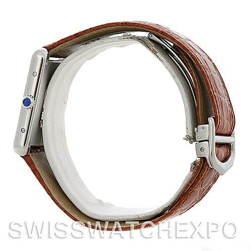 The image shows a Cartier Tank Solo W1018355 Men
s Stainless Steel Silver Dial W1018355 Men
s Stainless Steel Silver Dial watch viewed from the side, displaying the crown with a blue stone and the leather strap with its buckle.
