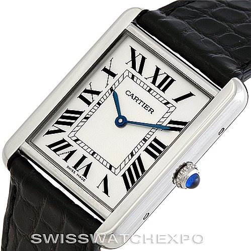The image shows a Cartier Tank Solo W1018355 Men's Stainless Steel Silver Dial W1018355 Men's Stainless Steel Silver Dial watch at an angled view, highlighting the rectangular face, Roman numerals, black leather strap, and blue sapphire crown.