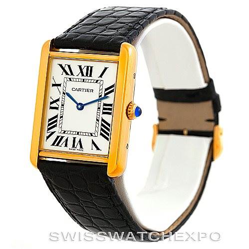 The image shows a side angle of the Cartier Tank Solo W1018855 Men
s Steel and Gold (two tone) Silver Dial W1018855 Men
s Steel and Gold (two tone) Silver Dial watch, highlighting its gold rectangular case, Roman numeral dial, and black leather strap.
