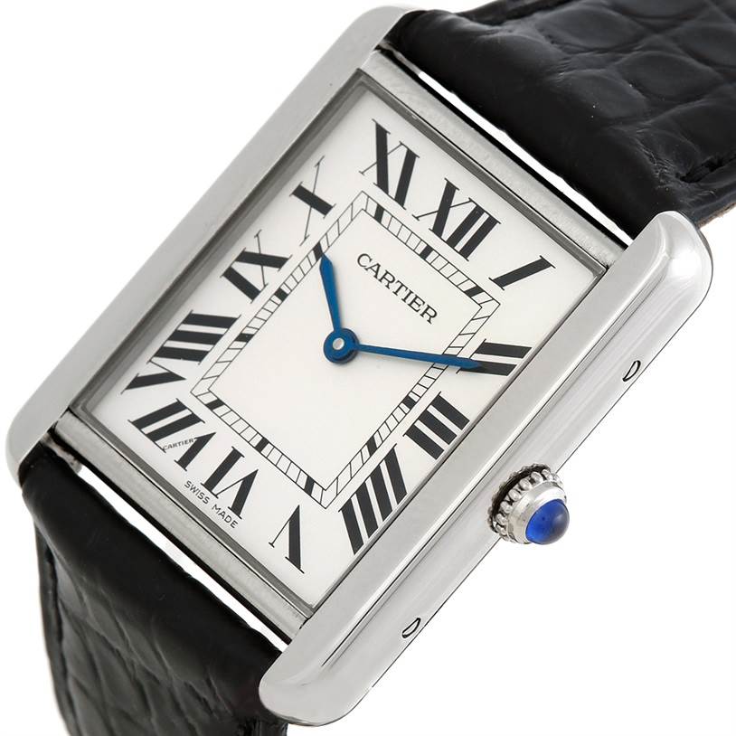 The image shows a close-up, angled view of the Cartier Tank Solo W1018355 Men
s Stainless Steel Silver Dial W1018355 Men
s Stainless Steel Silver Dial watch, highlighting its face, Roman numerals, hands, and crown with a blue cabochon.