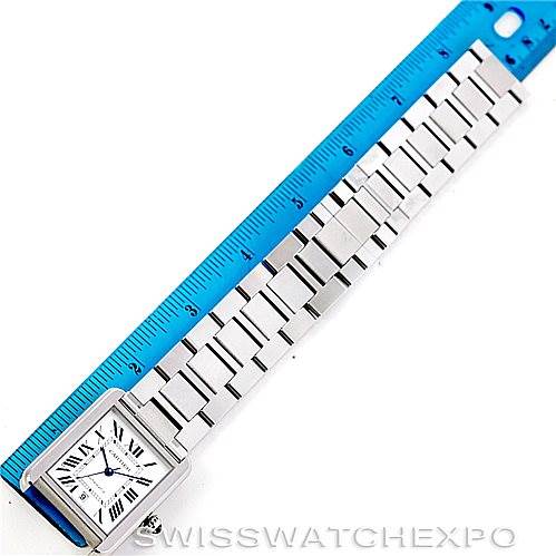 The image shows a Cartier Tank Solo W5200028 Men
s Stainless Steel Silver Dial W5200028 Men
s Stainless Steel Silver Dial watch placed next to a ruler, highlighting the entire face and strap from an aerial view.