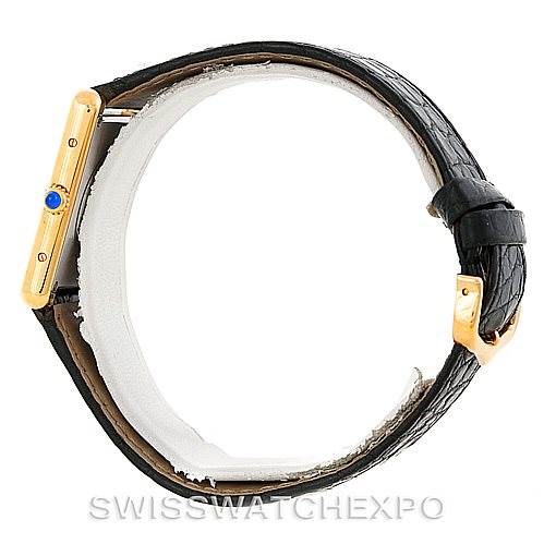 The image shows a Cartier Tank Solo W1018855 Men's Steel and Gold (two tone) Silver Dial W1018855 Men's Steel and Gold (two tone) Silver Dial watch from the side, highlighting its gold case, bejeweled crown, and black leather strap with a buckle.