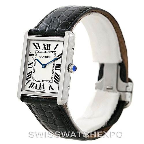 The Cartier Tank Solo W1018355 Men
s Stainless Steel Silver Dial W1018355 Men
s Stainless Steel Silver Dial watch is shown at an angle displaying the face, Roman numeral dial, blue hands, crown, and leather strap.