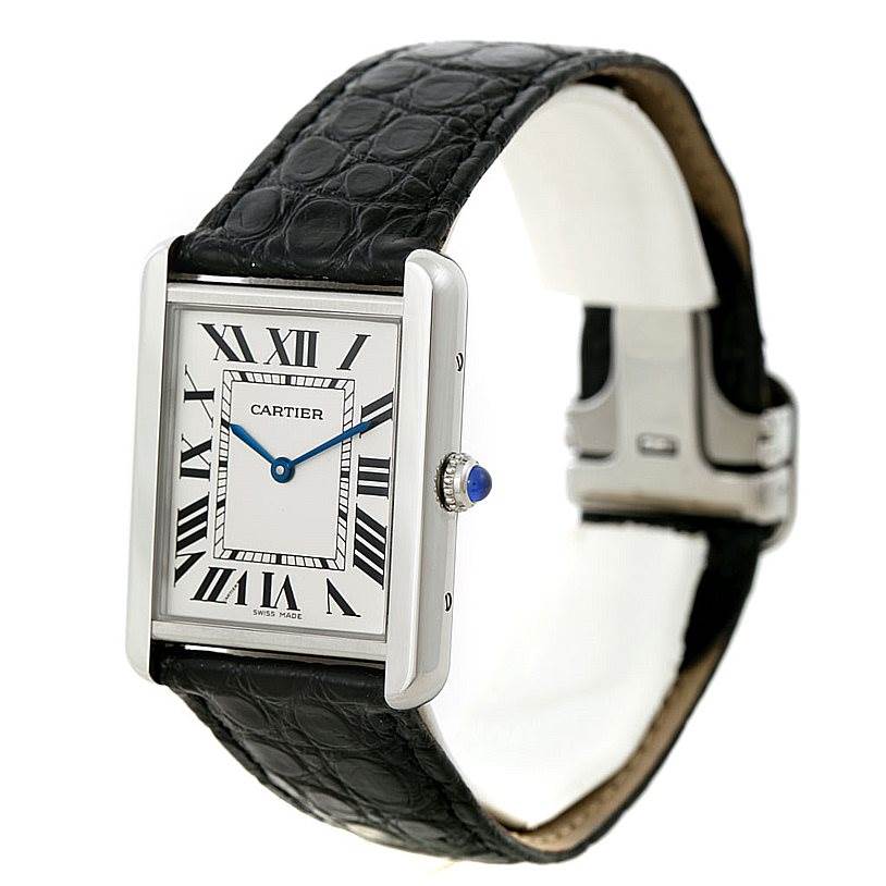 The image shows a Cartier Tank Solo W1018355 Men
s Stainless Steel Silver Dial W1018355 Men
s Stainless Steel Silver Dial watch at an angled view, highlighting its face, black leather strap, and blue gemstone crown.
