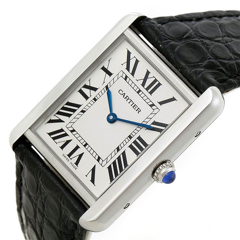 The image shows a close-up angle of the Cartier Tank Solo W1018355 Men
s Stainless Steel Silver Dial W1018355 Men
s Stainless Steel Silver Dial watch, highlighting its face, Roman numerals, blue hands, and black leather strap.