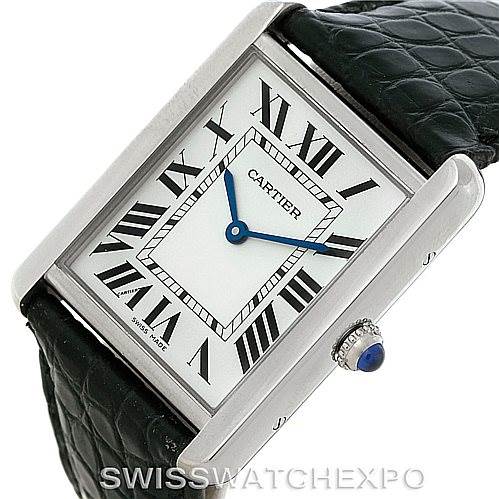 The image shows a Cartier Tank Solo W1018355 Men
s Stainless Steel Silver Dial W1018355 Men
s Stainless Steel Silver Dial watch at a slight angle, highlighting the face with Roman numerals, blue hands, and the crown with a blue cabochon.