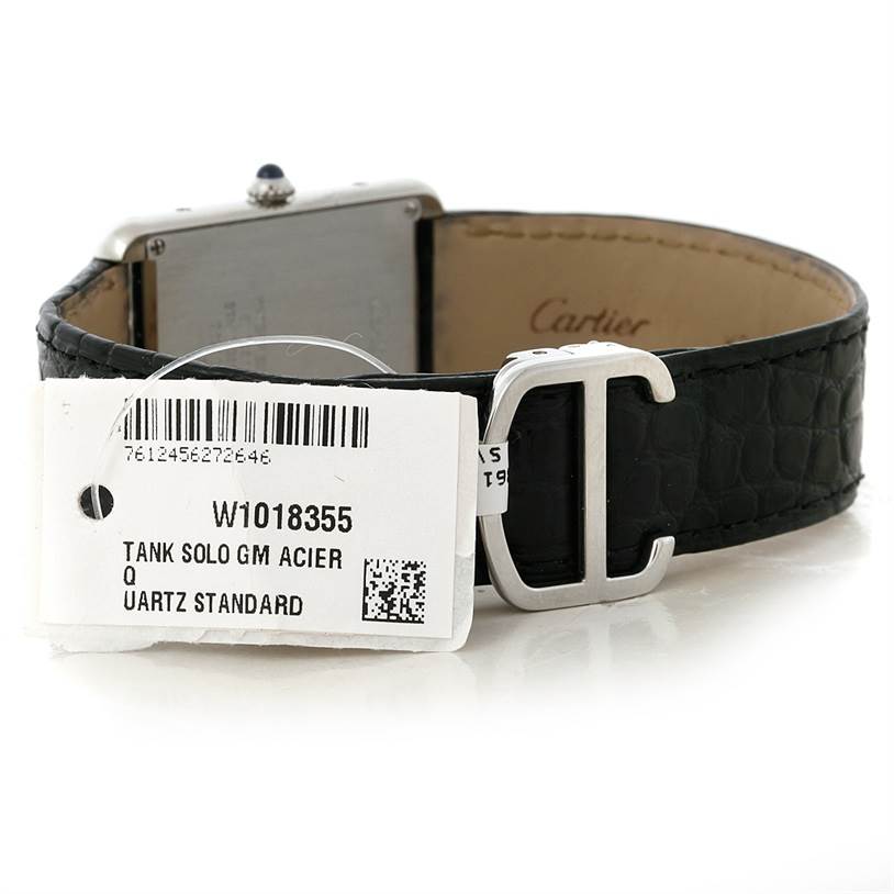 The image shows the back and side of the Cartier Tank Solo W1018355 Men
s Stainless Steel Silver Dial W1018355 Men
s Stainless Steel Silver Dial watch, highlighting its black leather strap and registration tag.