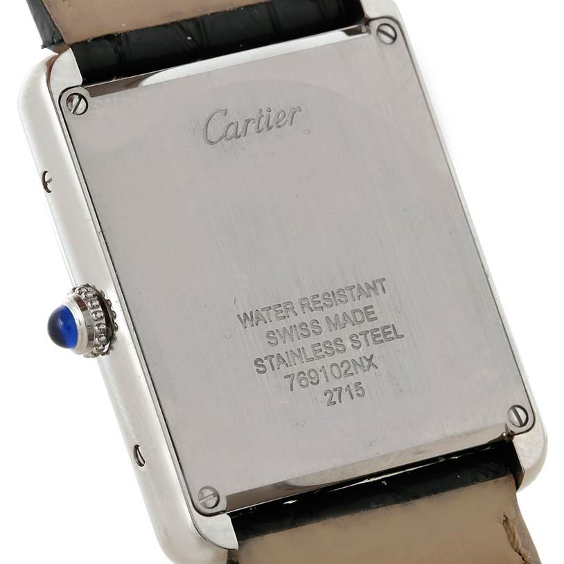 This image shows the back of a Tank Solo watch by Cartier, highlighting the inscriptions and the blue sapphire cabochon crown.