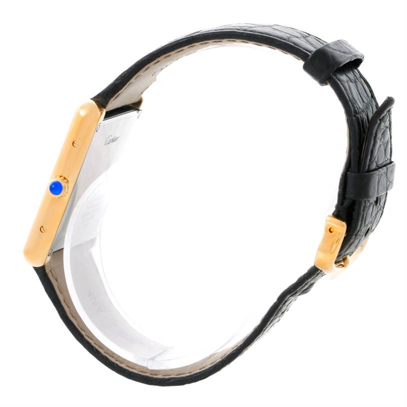 The image shows a side view of the Cartier Tank Solo W1018855 Men
s Steel and Gold (two tone) Silver Dial W1018855 Men
s Steel and Gold (two tone) Silver Dial watch, featuring its golden case, blue crown, and black leather strap.