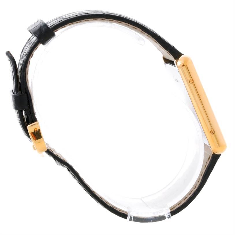 The image shows a side view of a Cartier Tank Solo W1018855 Men
s Steel and Gold (two tone) Silver Dial W1018855 Men
s Steel and Gold (two tone) Silver Dial watch, highlighting its gold case and black leather strap.