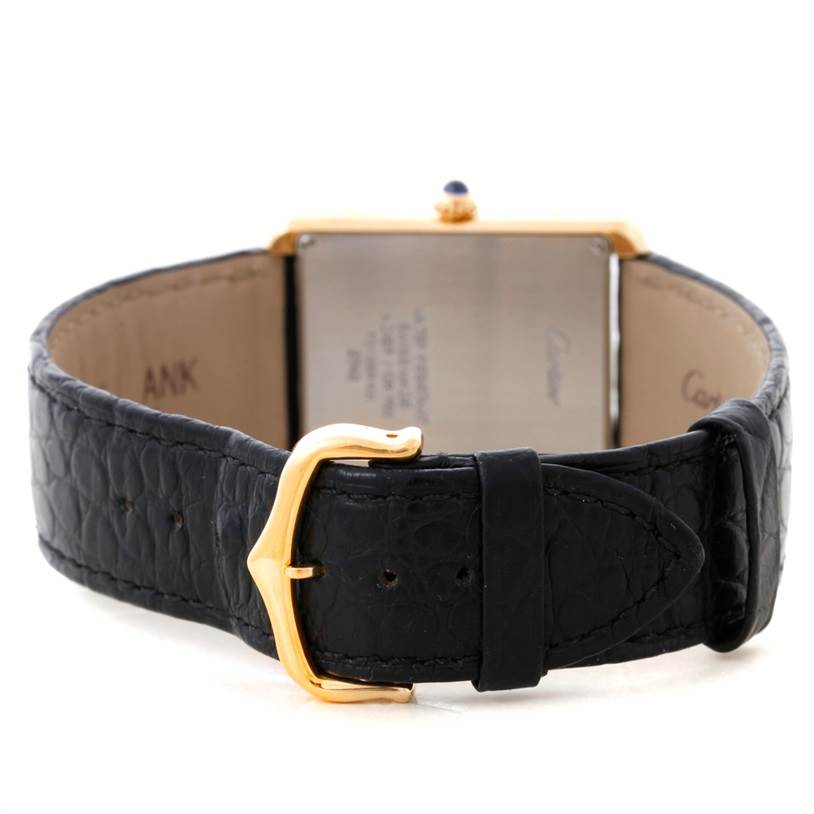 The image shows the back of the Cartier Tank Solo W1018855 Men
s Steel and Gold (two tone) Silver Dial W1018855 Men
s Steel and Gold (two tone) Silver Dial watch, highlighting the gold buckle and black leather strap.