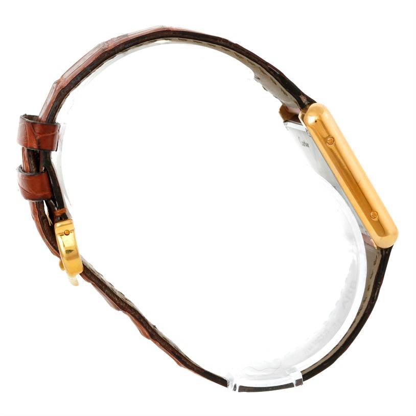 This side view of the Cartier Tank Solo W1018755 Women's Steel and Gold (two tone) Silver Dial W1018755 Women's Steel and Gold (two tone) Silver Dial watch shows its gold case and brown leather strap.