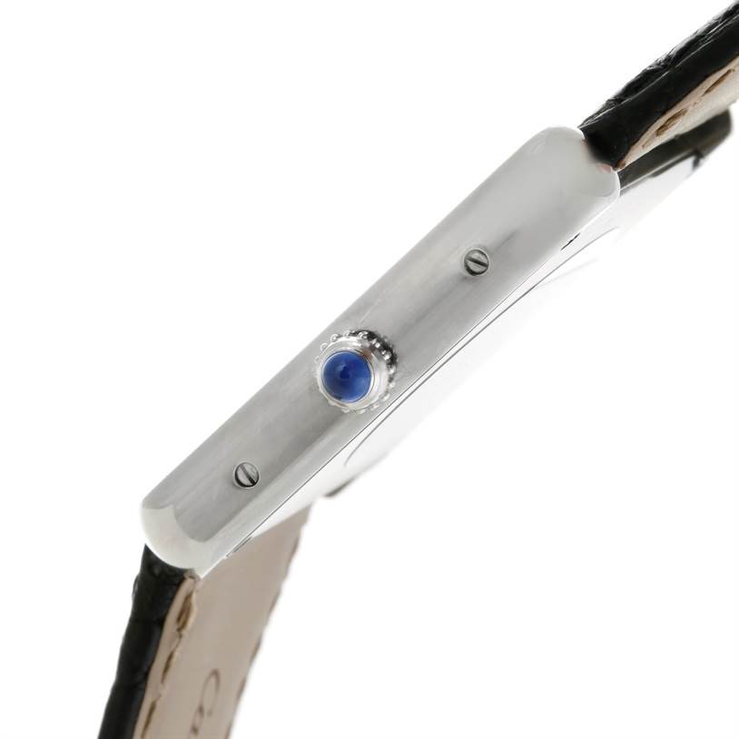 The image shows a side view of the Cartier Tank Solo W1018355 Men
s Stainless Steel Silver Dial W1018355 Men
s Stainless Steel Silver Dial watch, focusing on the crown with its blue cabochon.