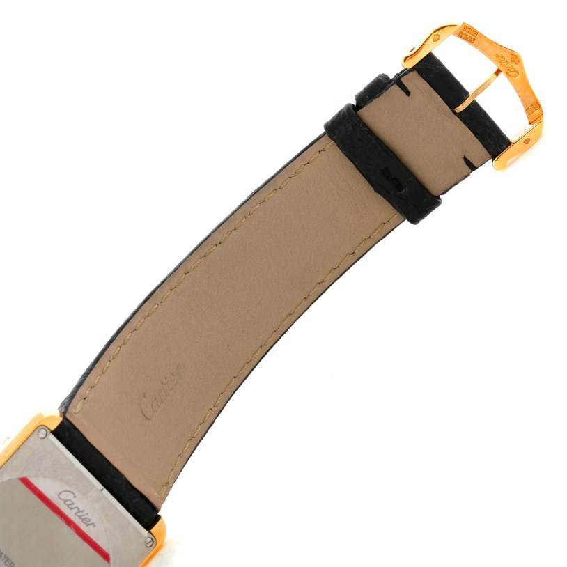 The image shows the back of the Cartier Tank Solo W1018855 Men
s Steel and Gold (two tone) Silver Dial W1018855 Men
s Steel and Gold (two tone) Silver Dial watch, focusing on the leather strap and gold buckle.