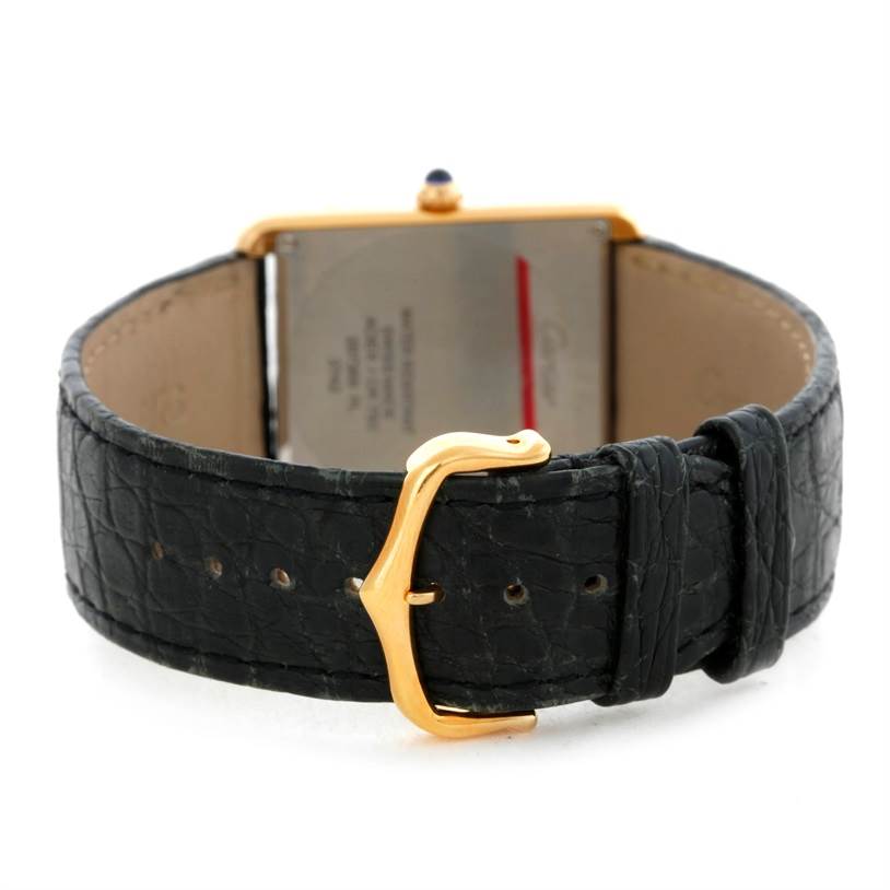 The image shows the back view of a Cartier Tank Solo W1018855 Men
s Steel and Gold (two tone) Silver Dial W1018855 Men
s Steel and Gold (two tone) Silver Dial watch, highlighting its black leather strap and gold buckle.