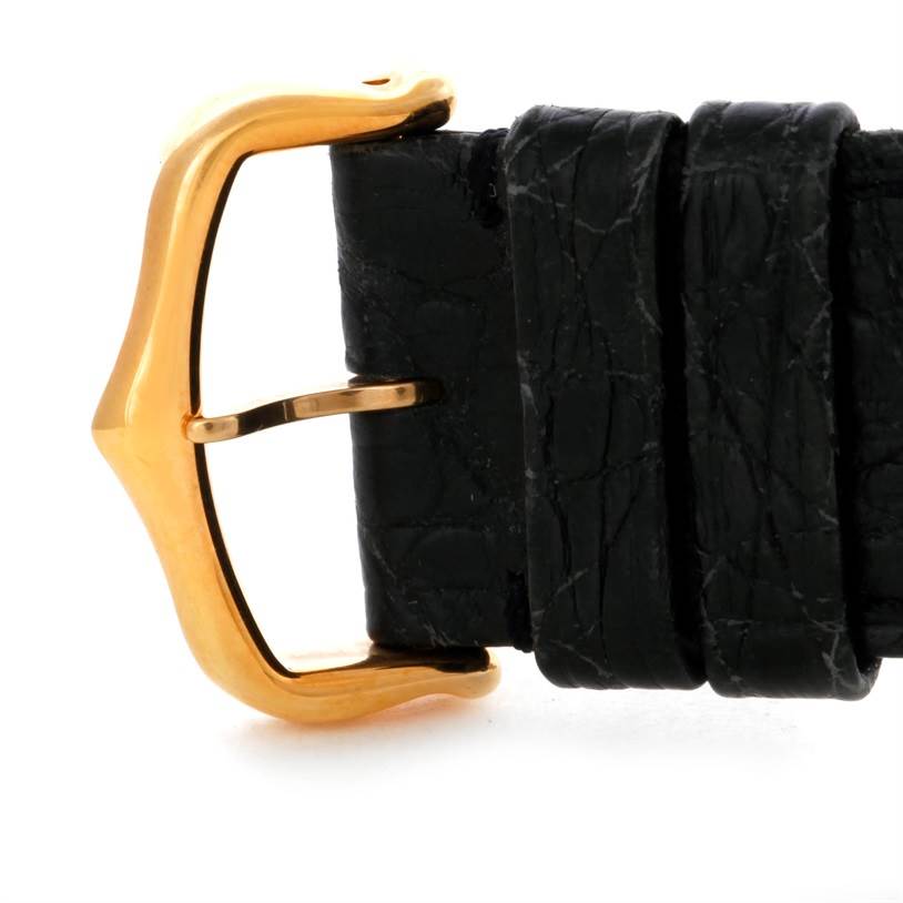 The image shows a close-up view of the gold-colored buckle and black leather strap of a Cartier Tank Solo W1018855 Men
s Steel and Gold (two tone) Silver Dial W1018855 Men
s Steel and Gold (two tone) Silver Dial watch.