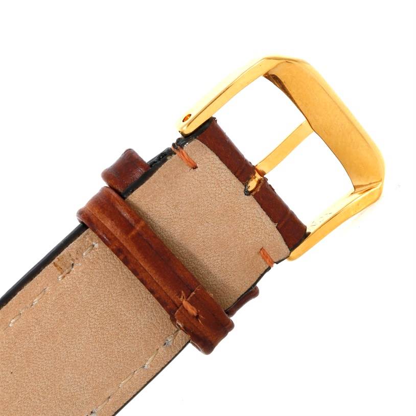 The image shows a close-up of the brown leather strap and gold buckle of a Cartier Tank Solo W1018855 Men
s Steel and Gold (two tone) Silver Dial W1018855 Men
s Steel and Gold (two tone) Silver Dial watch.