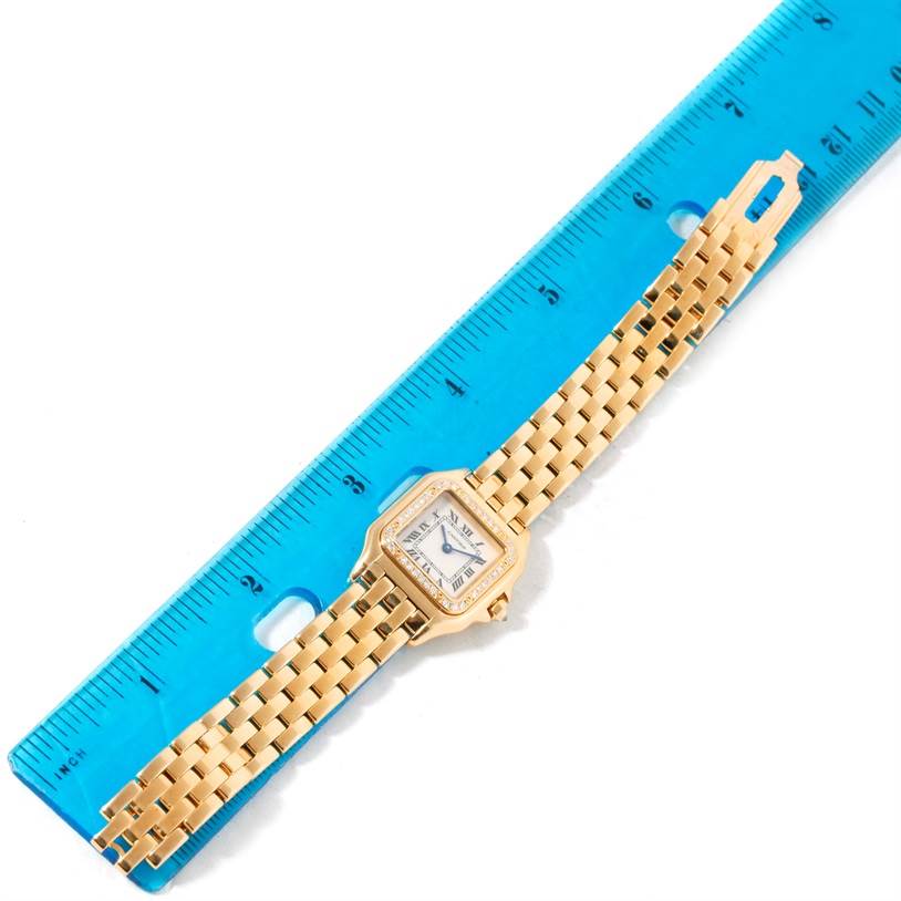 The Cartier Panthere WF3070B9 Yellow Gold Silver Dial WF3070B9 Yellow Gold Silver Dial watch is shown from a top-down angle, lying flat alongside a blue ruler for scale.