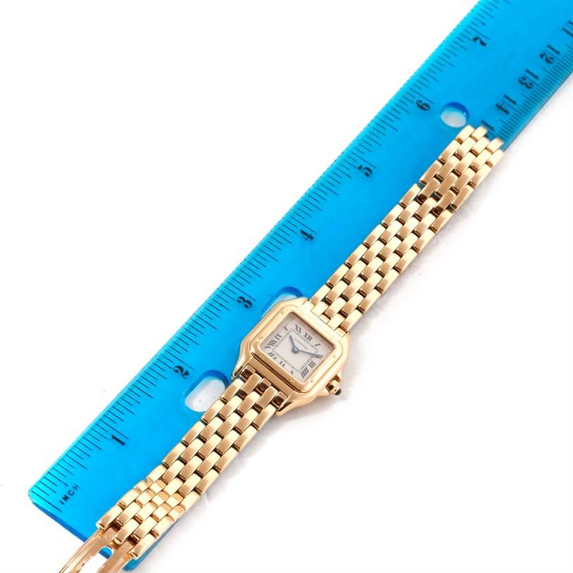 The image shows a top-down view of the Cartier Panthere W25022B9 Women's Yellow Gold Silver Dial W25022B9 Women's Yellow Gold Silver Dial watch alongside a blue ruler for size reference.