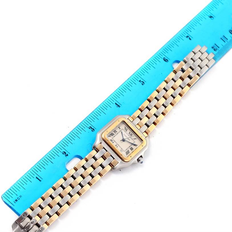 The image shows a top-down view of a Cartier Panthere W25028B6 Women's Steel and Gold (two tone) Silver Dial W25028B6 Women's Steel and Gold (two tone) Silver Dial watch, including the face, bezel, and bracelet, alongside a blue ruler for scale.