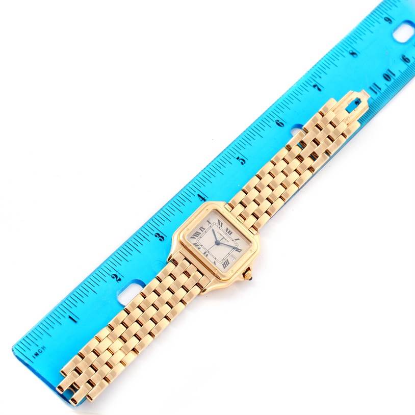 The Cartier Panthere W25014B9 Yellow Gold Silver Dial W25014B9 Yellow Gold Silver Dial watch is shown from a top-down angle next to a blue ruler, displaying its face and bracelet.