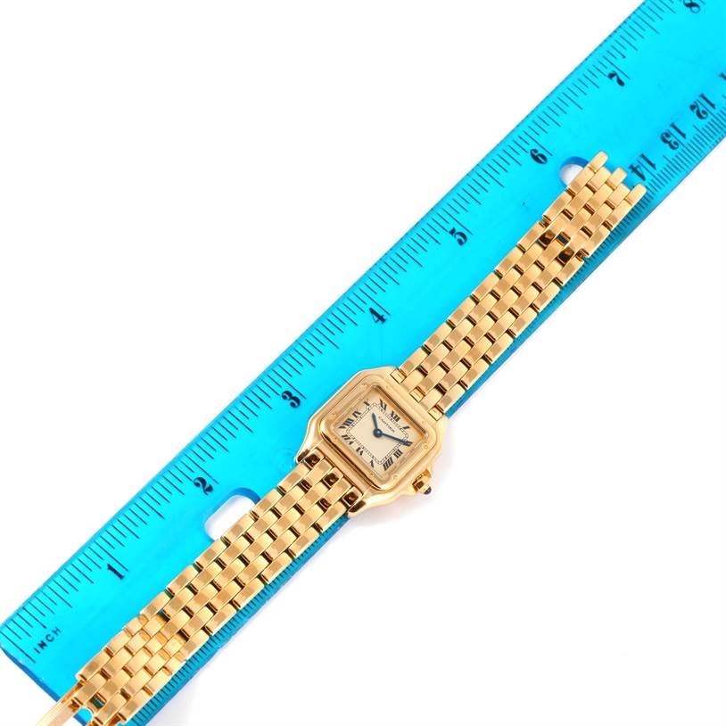 The image shows a Panthere de Cartier watch with a gold bracelet alongside a blue ruler for size reference.