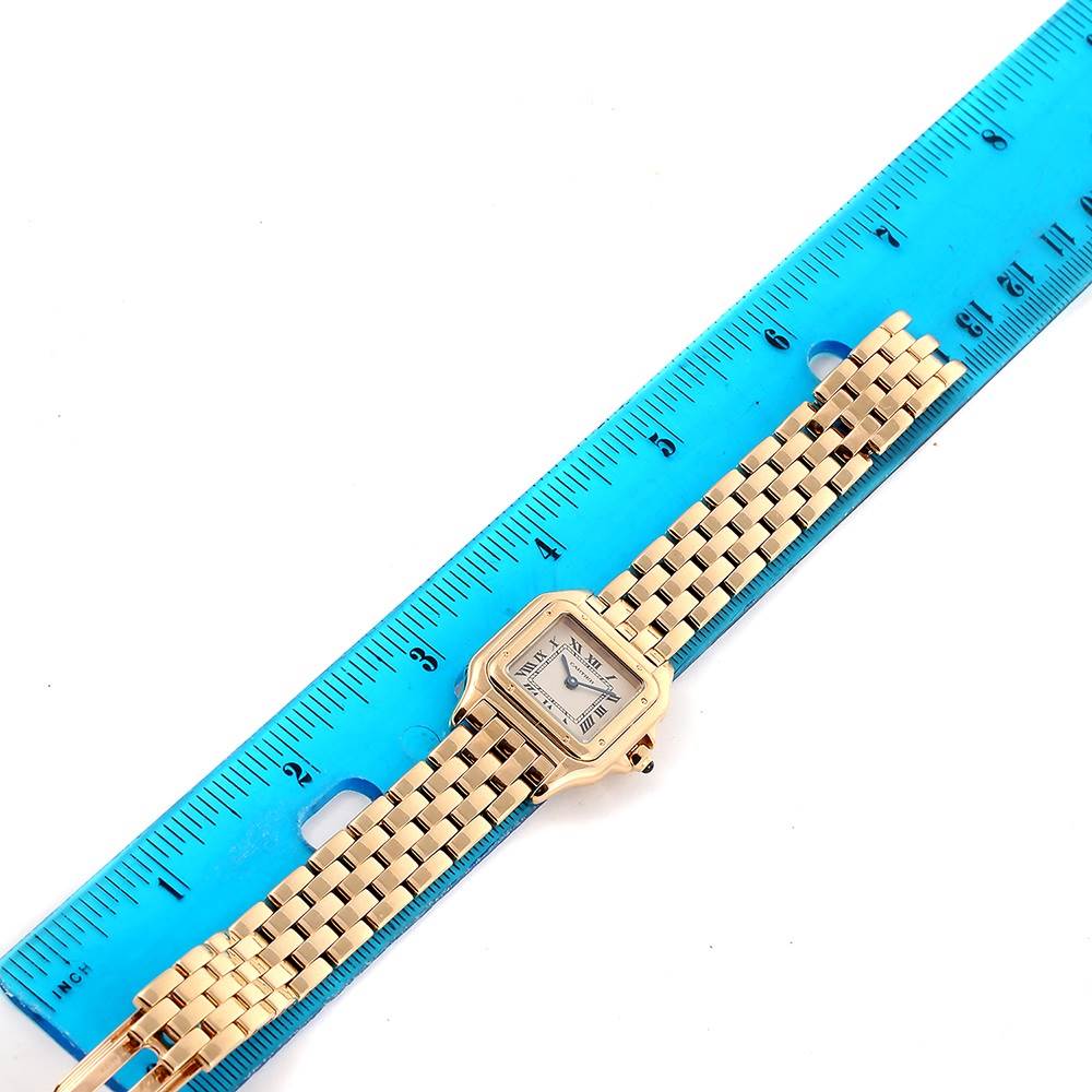 The image shows a gold Cartier Panthere W25022B9 Women's Yellow Gold Silver Dial W25022B9 Women's Yellow Gold Silver Dial watch laid flat next to a blue ruler for size reference.