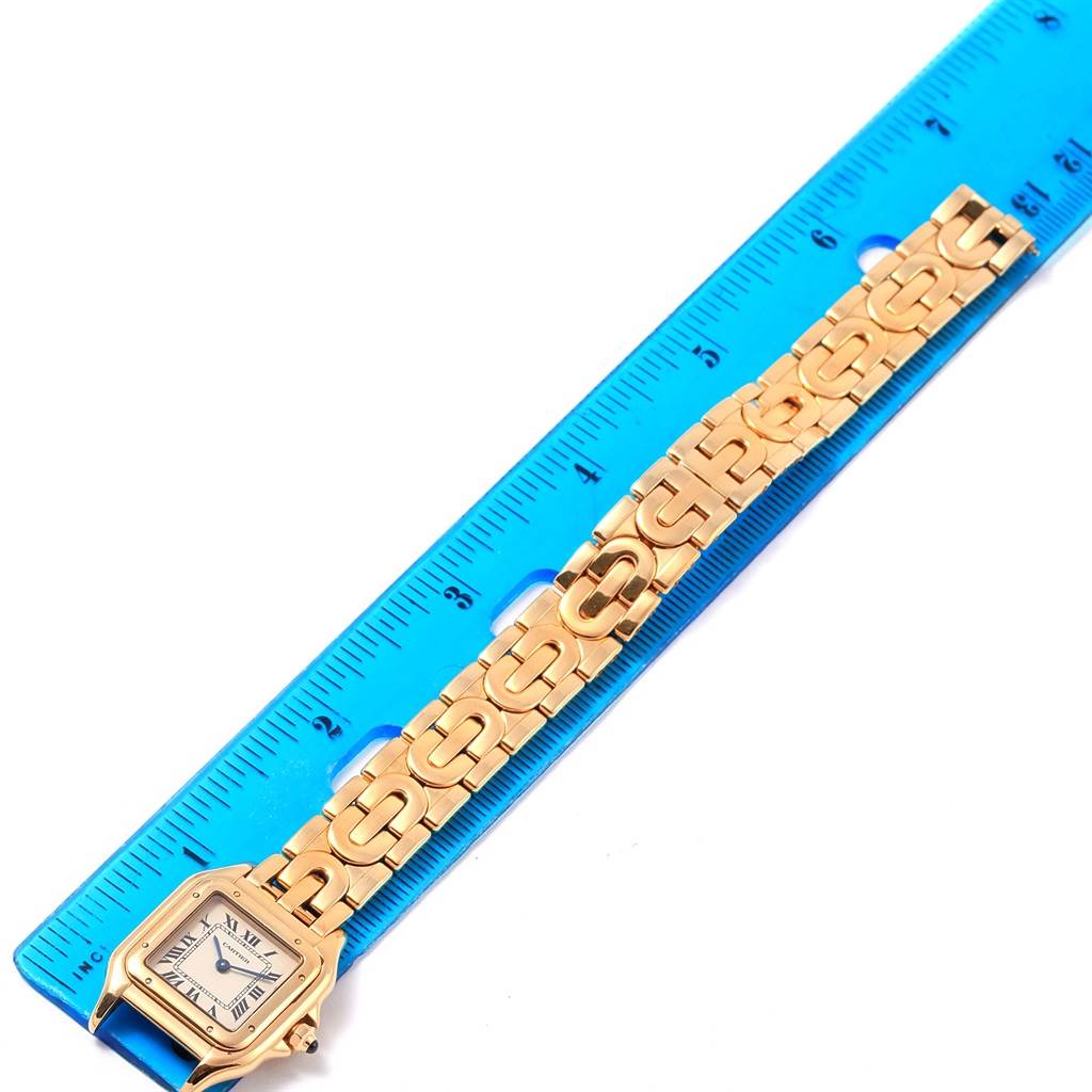 The image shows the Panthere model by Cartier, laying flat alongside a blue ruler, displaying its gold links and square face.