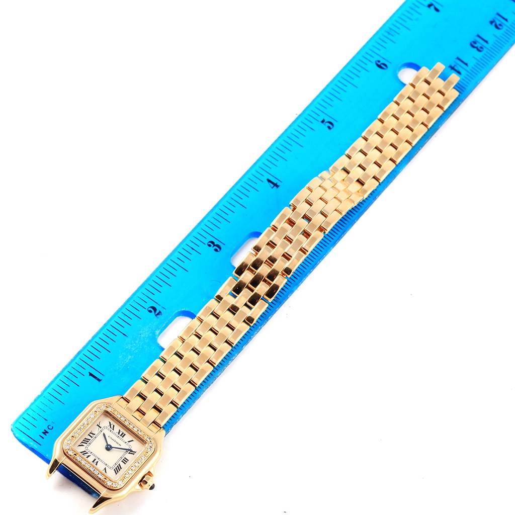 The image shows a full view of a Cartier Panthere WF3070B9 Women's Yellow Gold Silver Dial WF3070B9 Women's Yellow Gold Silver Dial model watch laid next to a blue ruler for measurement.